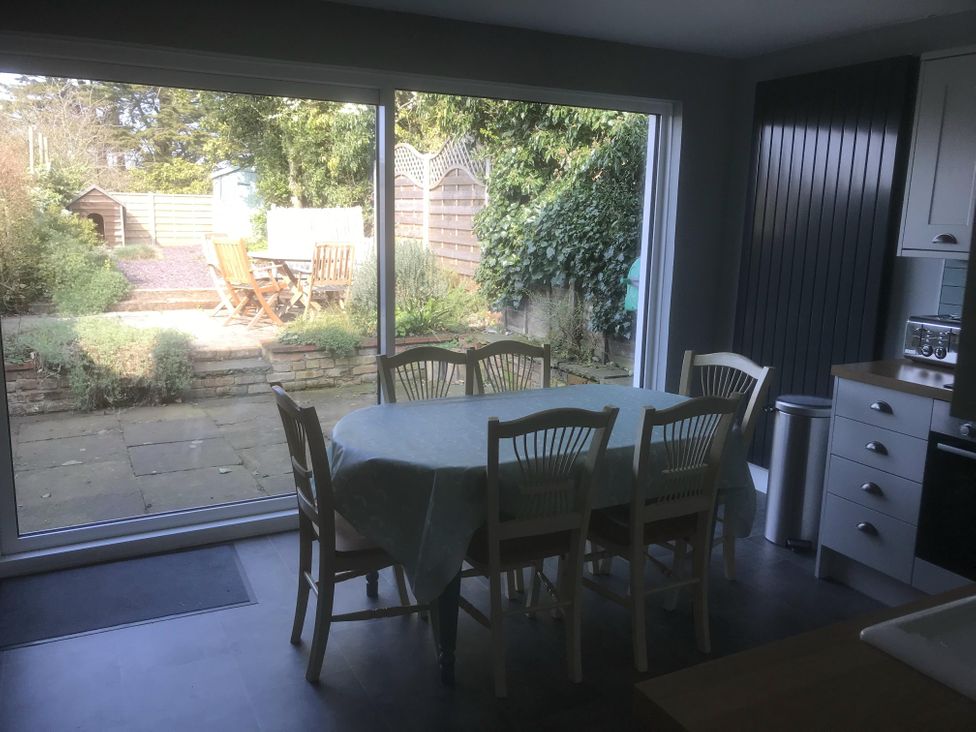 A kitchen with dining table and chairs overlooking a garden at tbc