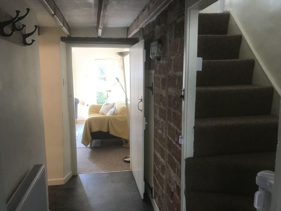 A hallway with stairs and hooks at tbc 