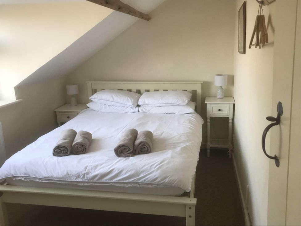 A bedroom with a bed and bedside tables at tbc