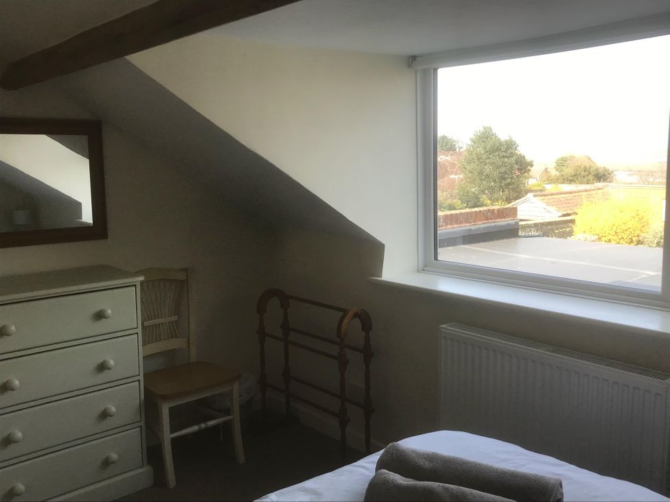 A bedroom with a dresser and chair at tbc 