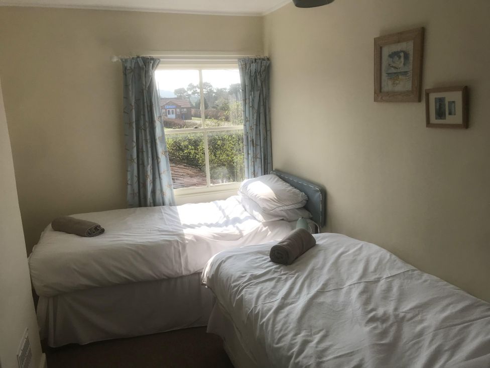 A bedroom with two single beds and a window at tbc 