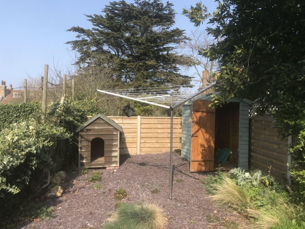 A garden with a dog house and a shed at tbc