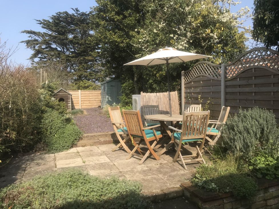 A garden with a table and chairs under an umbrella at tbc