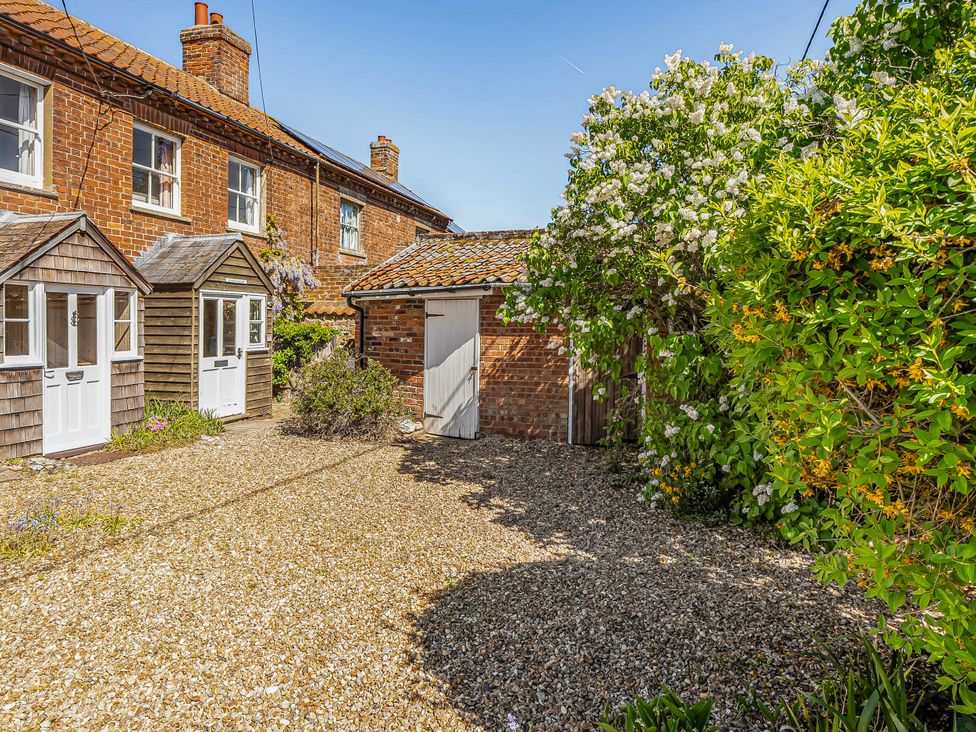 An outdoor area with a garden shed and flowering plants at Coastal cottage near harbour, beach and pubs, Brancaster