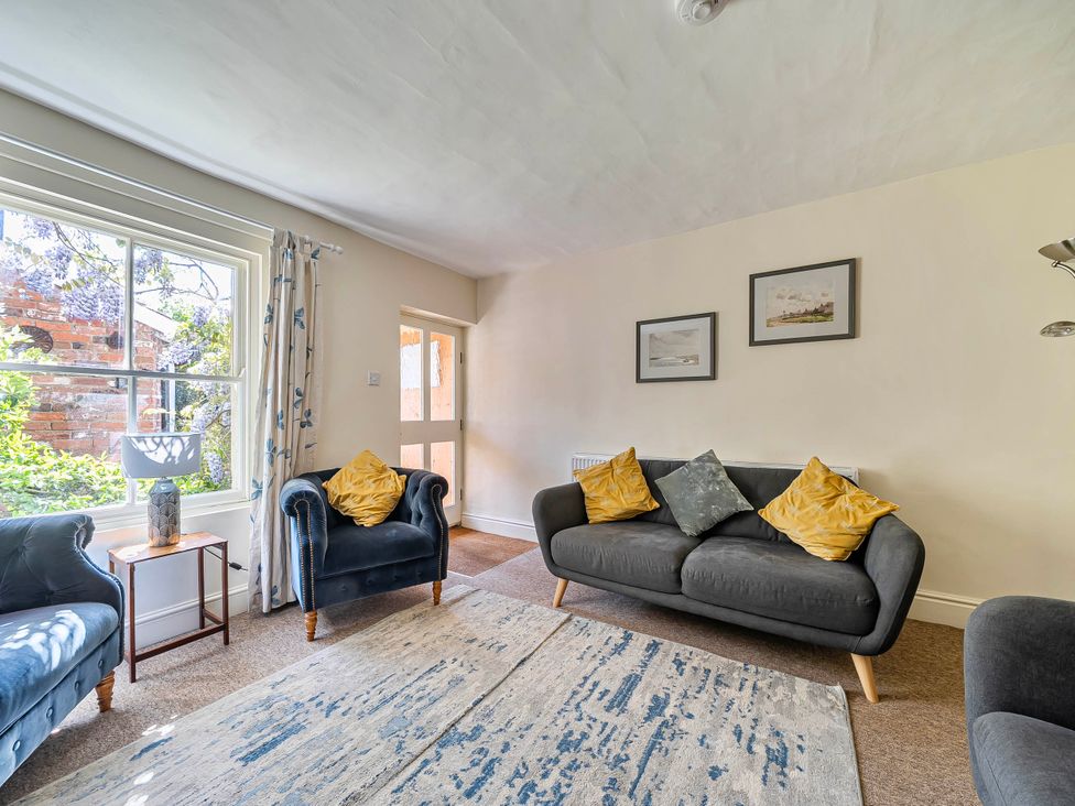 A living room with a sofa and armchair at Coastal cottage near harbour, beach and pubs in Brancaster