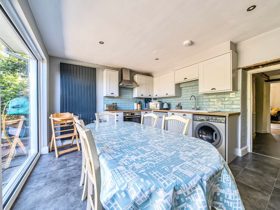 A kitchen with a table and chairs at Coastal cottage near harbour, beach and pubs in Brancaster