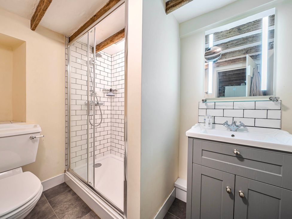 A bathroom with a shower, toilet, and sink at Coastal cottage near harbour, beach and pubs in Brancaster