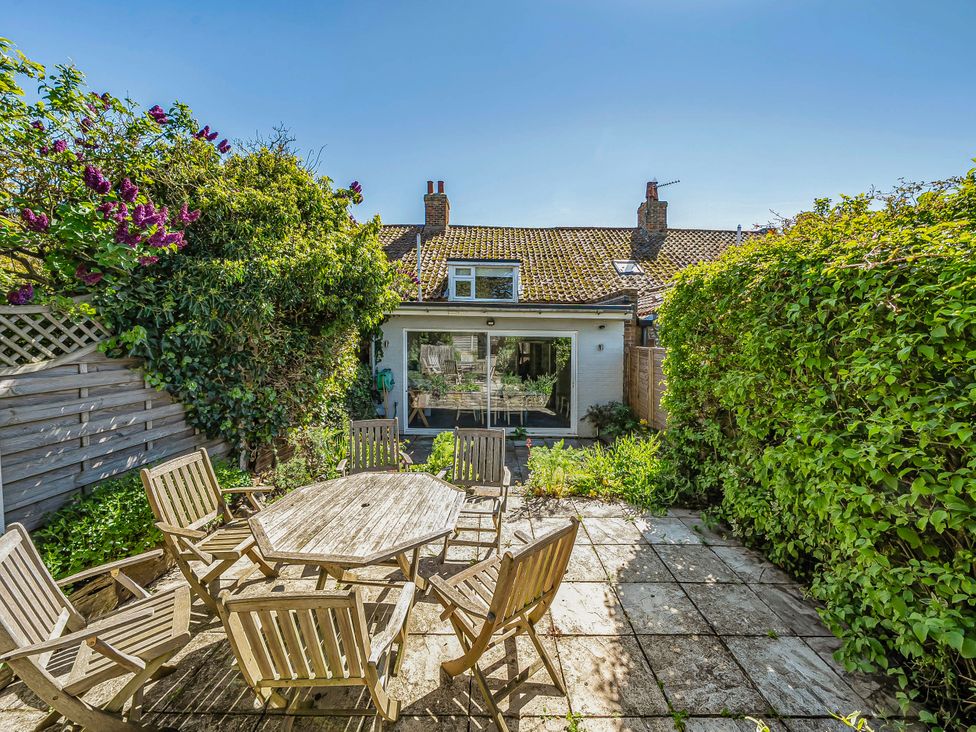 A garden with a table and chairs at Coastal cottage near harbour, beach and pubs in Brancaster