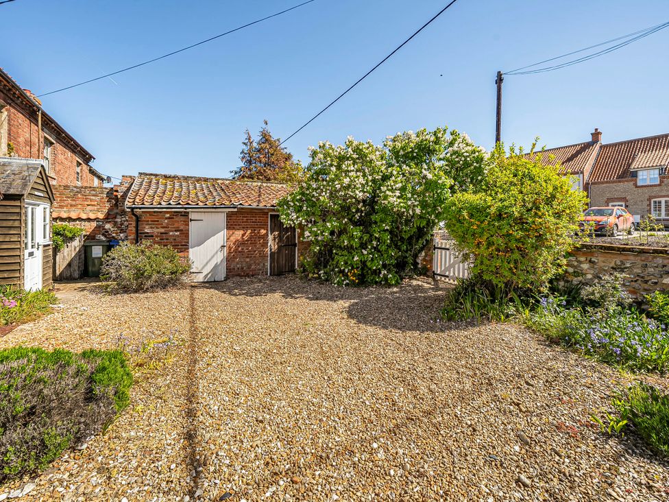An outdoor area with a garage and plants at Coastal cottage near harbour, beach and pubs in Brancaster