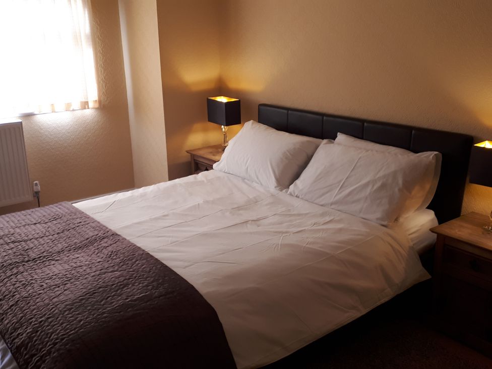 A bedroom with a double bed and nightstand at tbc in 