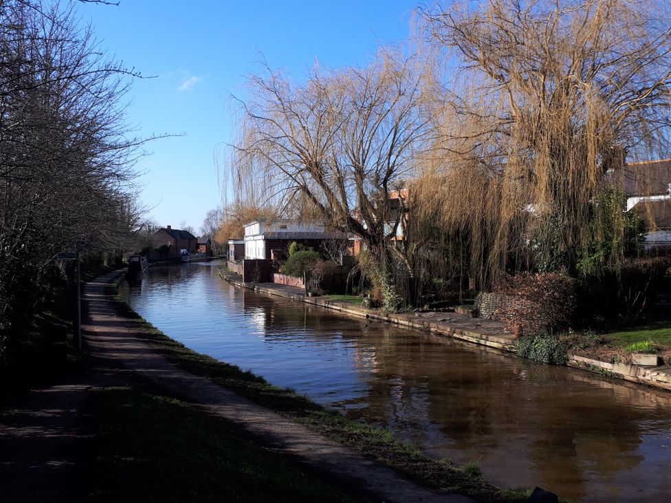 A canal with trees and houses along the bank