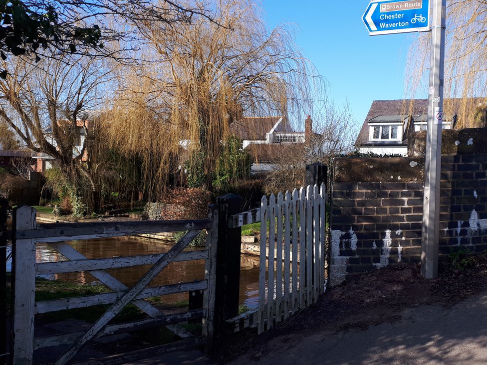 A view of a gate and a river with trees and houses at tbc in 