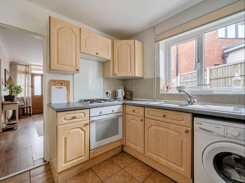 A kitchen with cabinets, stove, washing machine at Village retreat with canal walk into Chester, Christleton