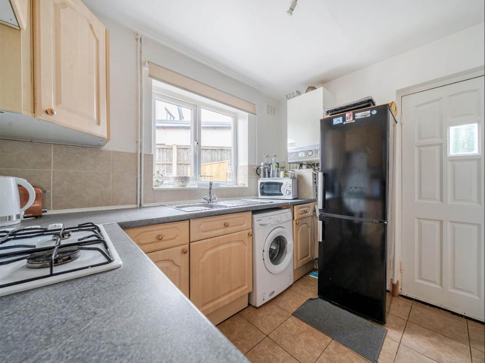 A kitchen with appliances including a stove, microwave, and washing machine at Village retreat with canal walk into Chester, Christleton