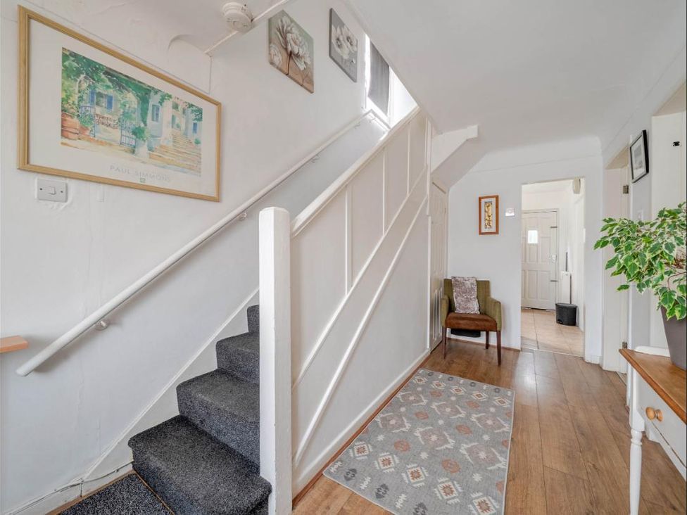A hallway with a staircase and a chair at Village retreat with canal walk into Chester