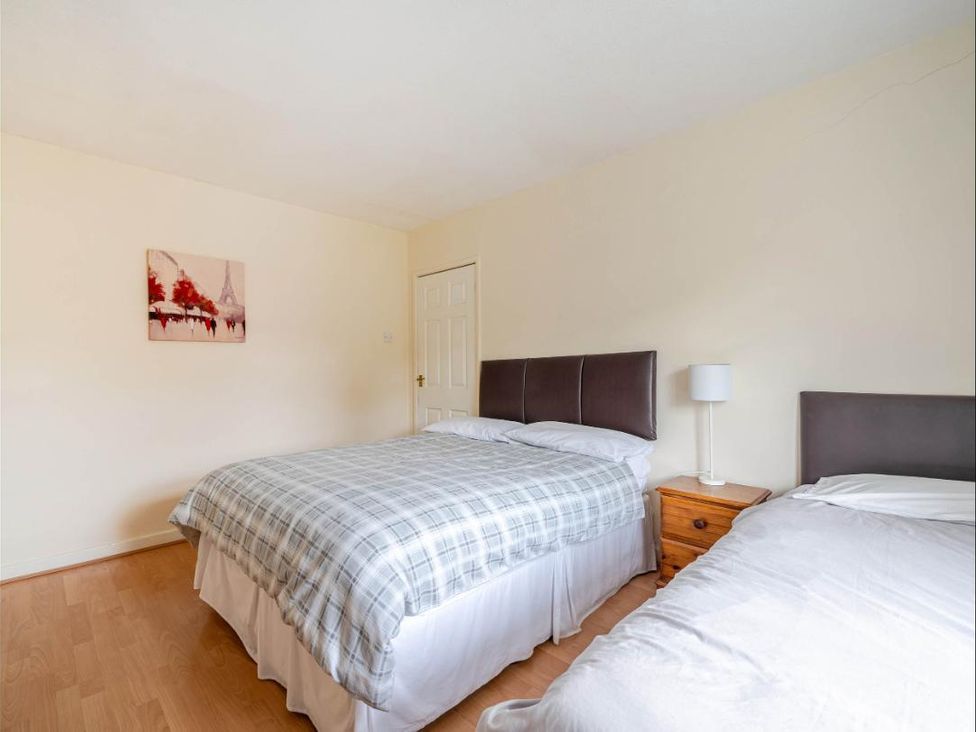 A bedroom with two beds and a nightstand at Village retreat with canal walk into Chester Christleton