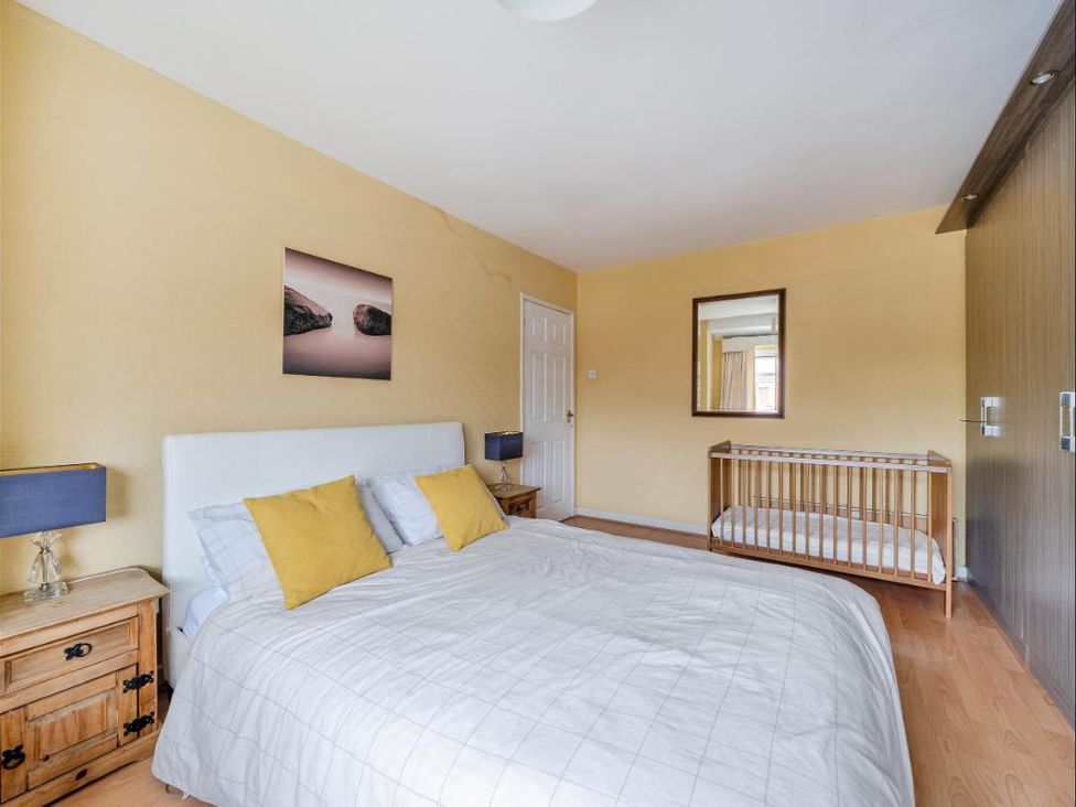 A bedroom with a bed and a crib at Village retreat with canal walk into Chester, Christleton