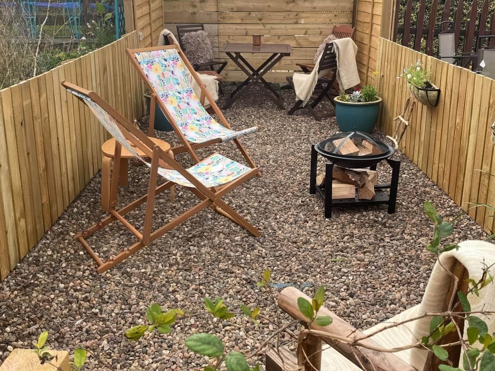 A garden area with deck chairs and a small table at Pet-friendly coastal flat with fire pit and views Newburgh, Fife