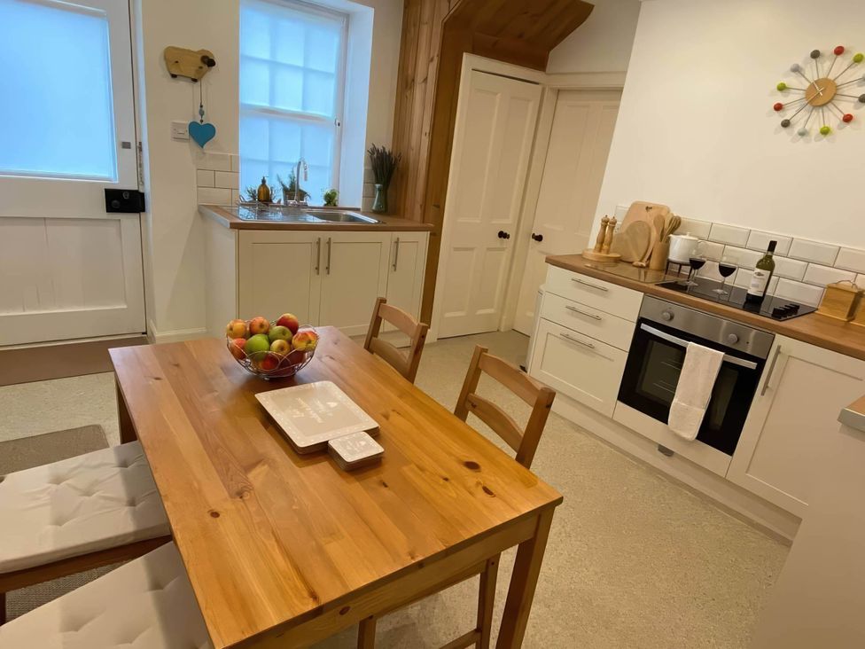 A kitchen with a table and bowl of fruit at Pet-friendly coastal flat with fire pit and views, Newburgh, Fife