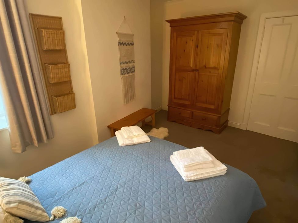 A bedroom with a bed, wardrobe, and shelf at Pet-friendly coastal flat with fire pit and views, Newburgh, Fife