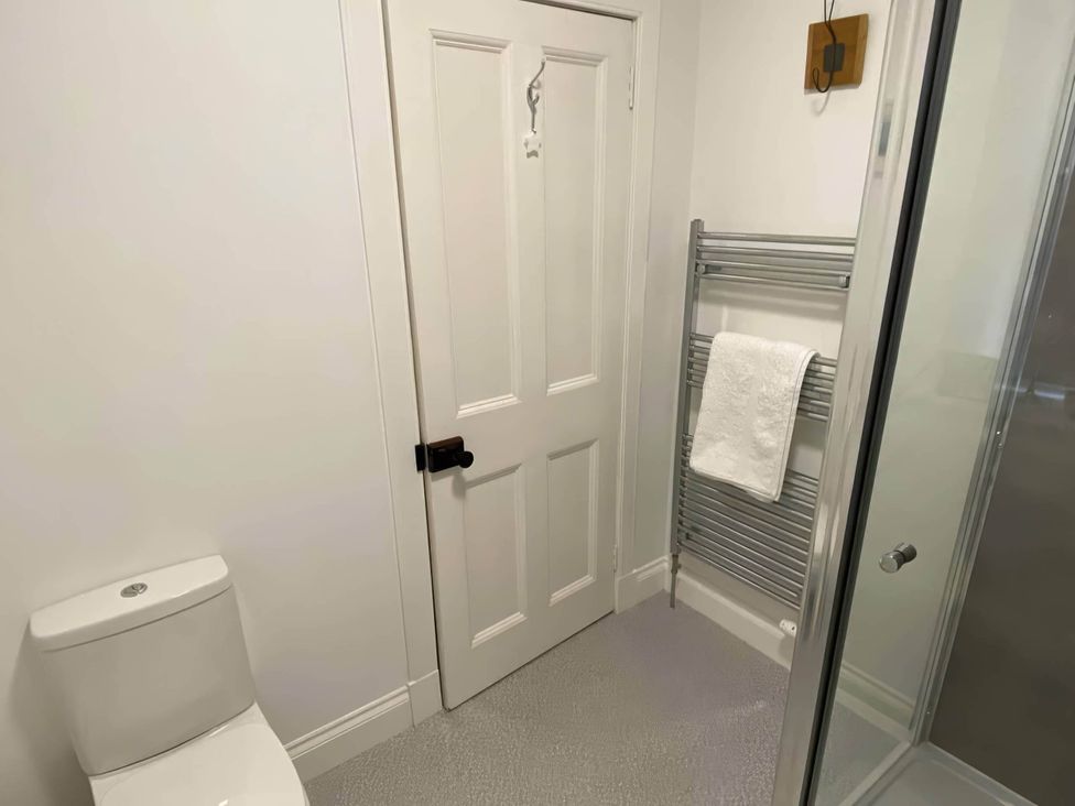 A bathroom with a toilet, towel rail, and shower at Pet-friendly coastal flat with fire pit and views, Newburgh, Fife