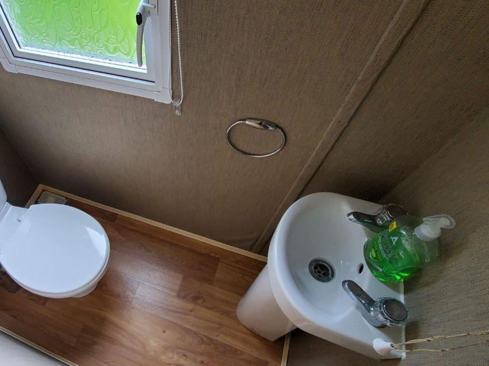 A bathroom with a toilet and a sink at tbc