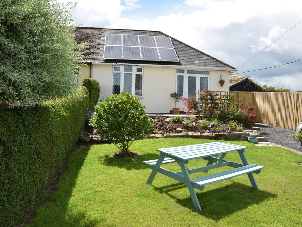 A house with solar panels and a picnic table in the garden at tbc