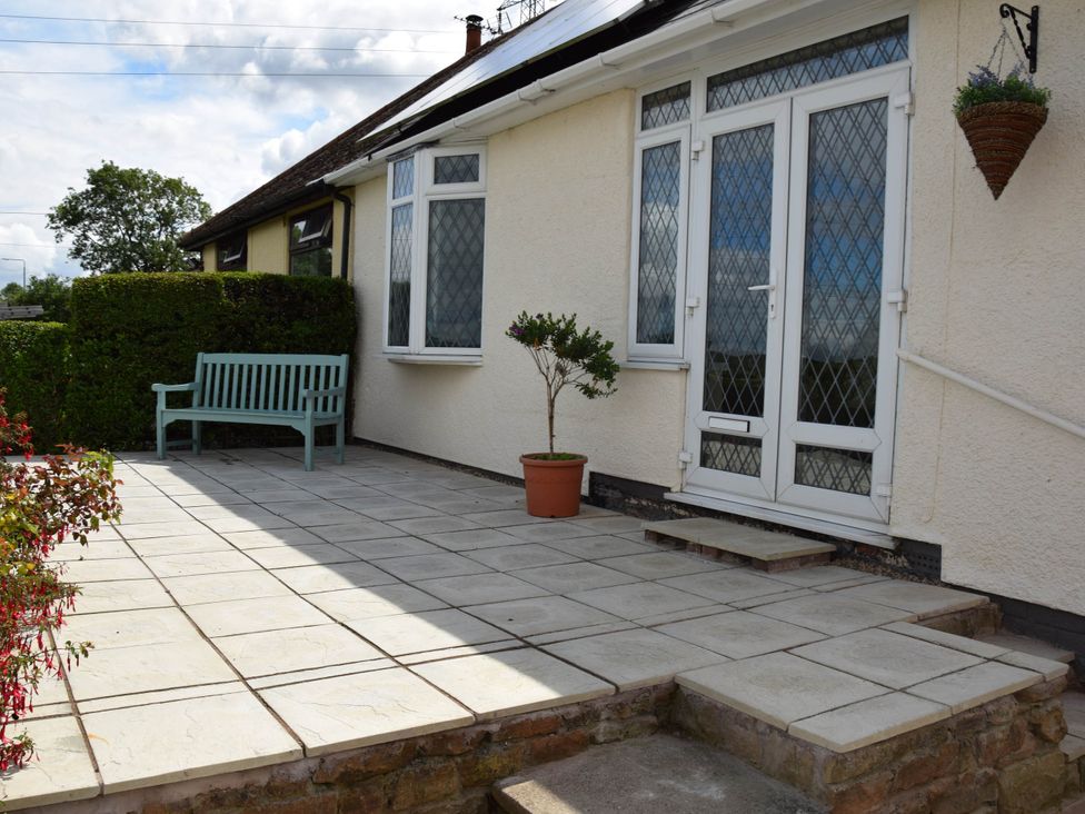 A garden area with a bench and potted plant at tbc