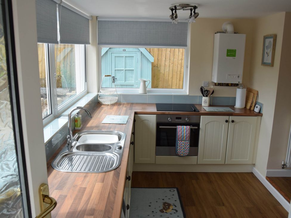 A kitchen with a sink, oven, and window at tbc