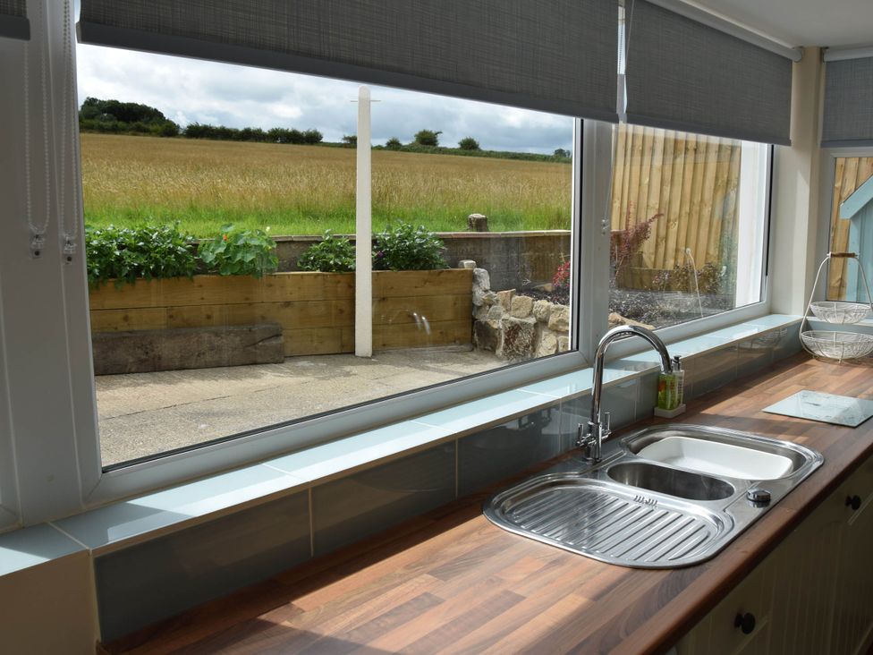 A kitchen with a sink and garden view at The Old Barn in Manchester