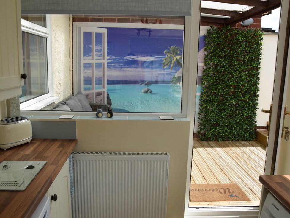 A kitchen with a window view of tropical scenery at tbc 