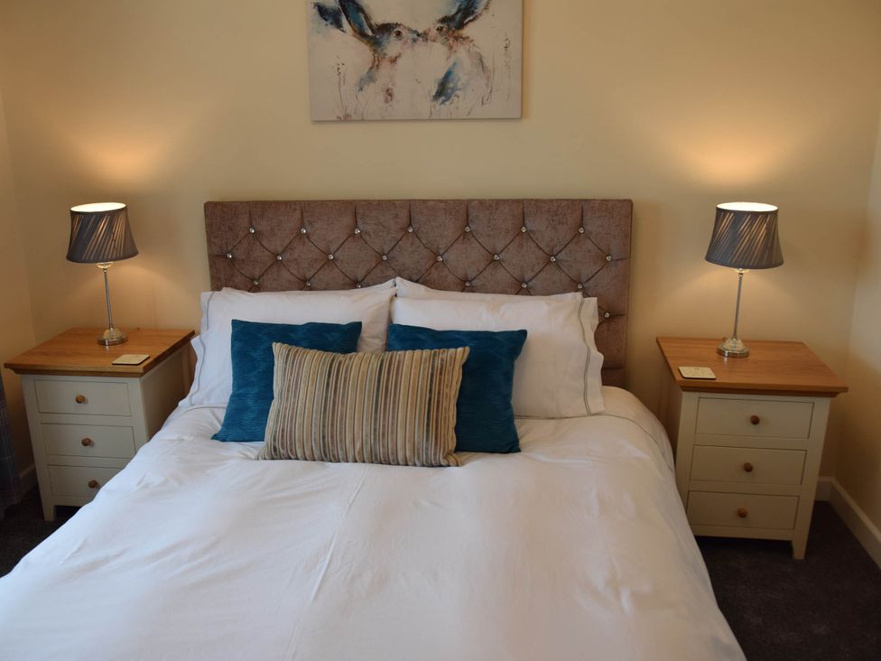 A bedroom with a bed and nightstands at tbc 