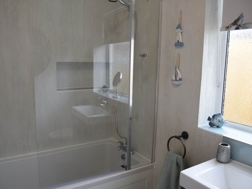 A bathroom with a bathtub, sink, and decorative elements at tbc