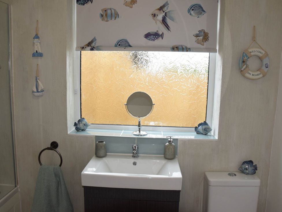 A bathroom with a sink, mirror, and toilet at tbc 