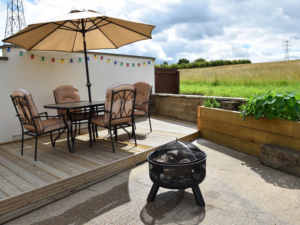 An outdoor dining area with a table and chairs at tbc