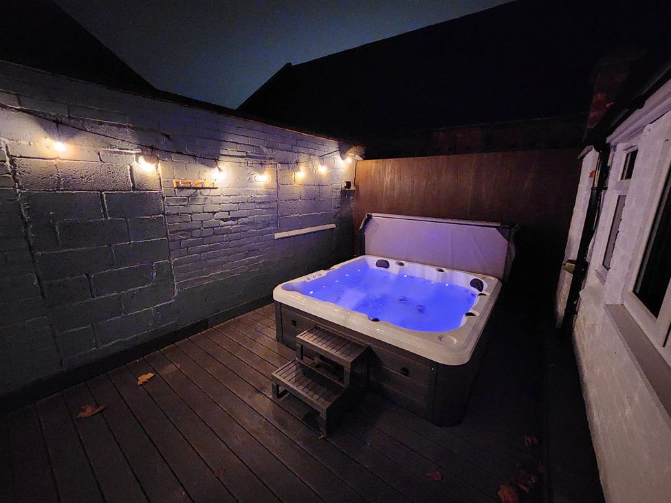 A hot tub with lights on wood decking at tbc 