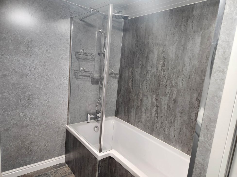 A bathroom with a bathtub and shower at tbc 