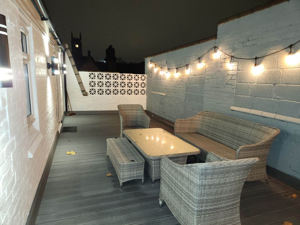 An outdoor terrace with seating and string lights at tbc in 