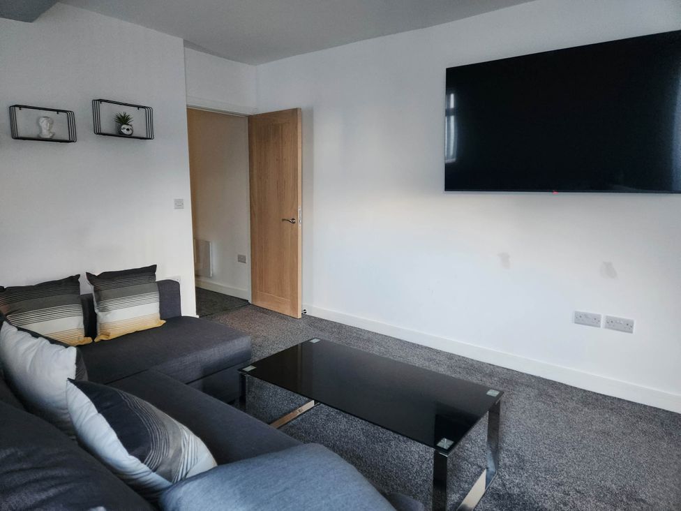 A living room with a sofa and a television at tbc 