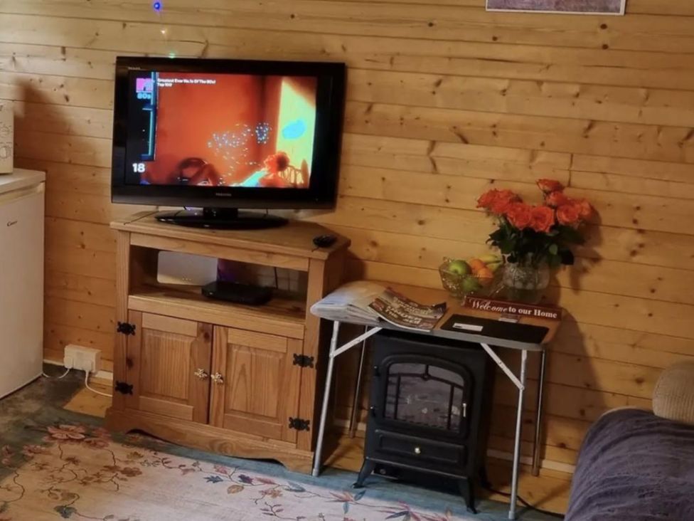 A living room with a television and a coffee table at tbc in 