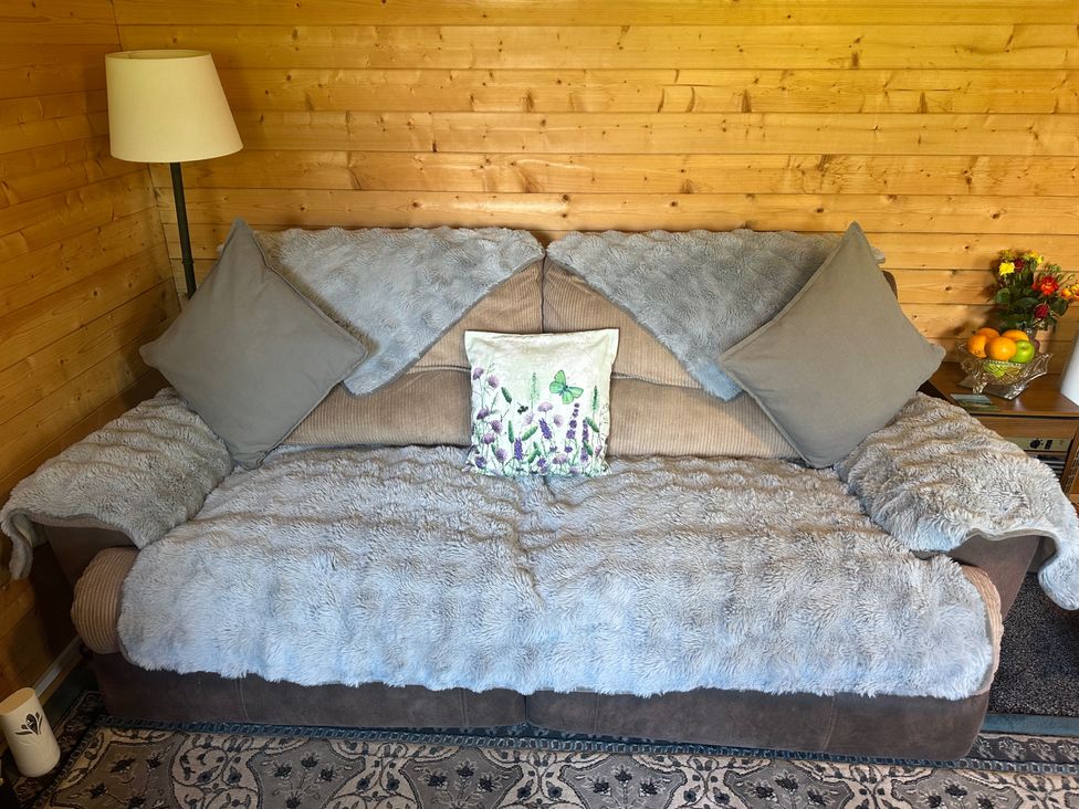 A sofa with pillows and decorative cushion in a snug at tbc