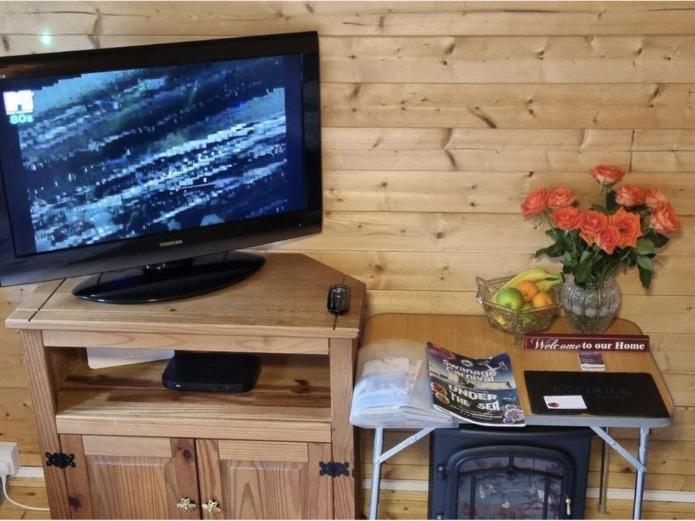 A living room with a television and shelf unit at tbc 