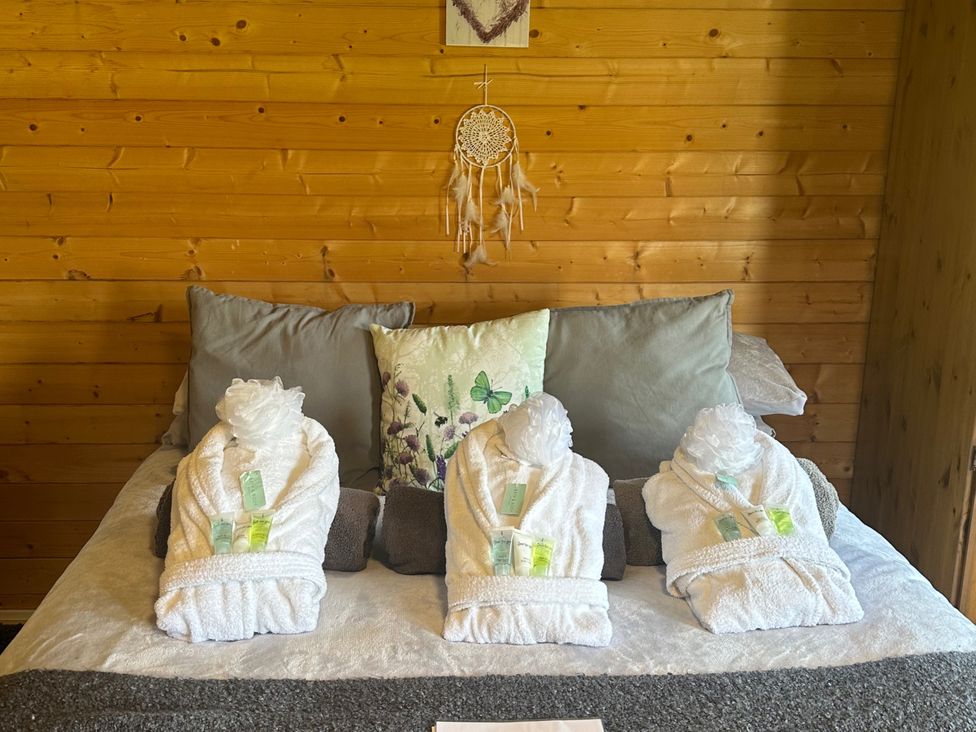 A bedroom with towels arranged on the bed at tbc