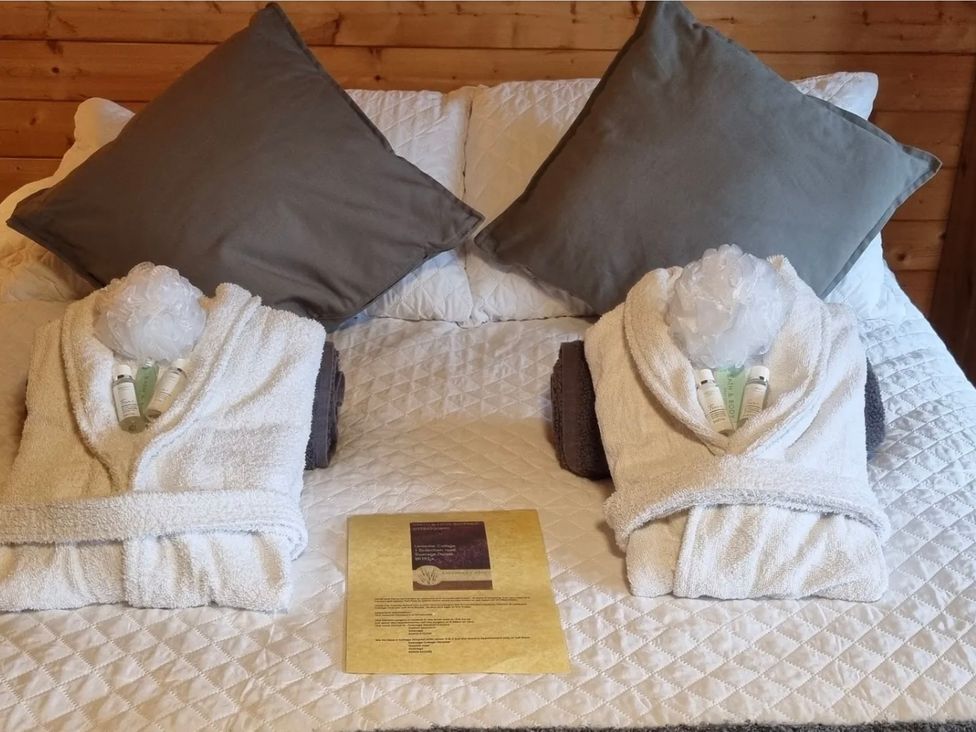 A bed with towels and bath products in a cabin at tbc