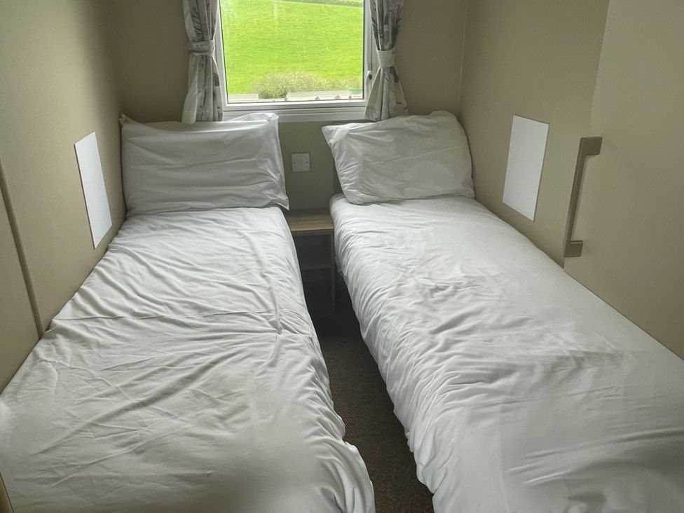 A bedroom with two single beds and a window at tbc in 