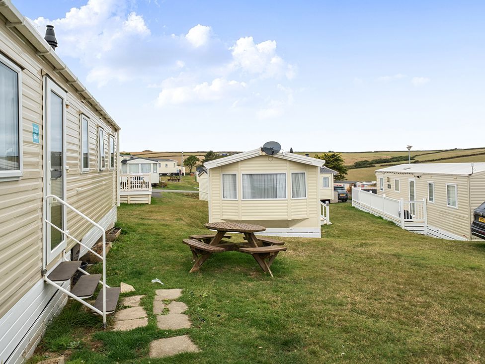 A mobile home with a picnic table and grass area near Pet-friendly lodge near Fistral Beach Fistral Beach, Newquay