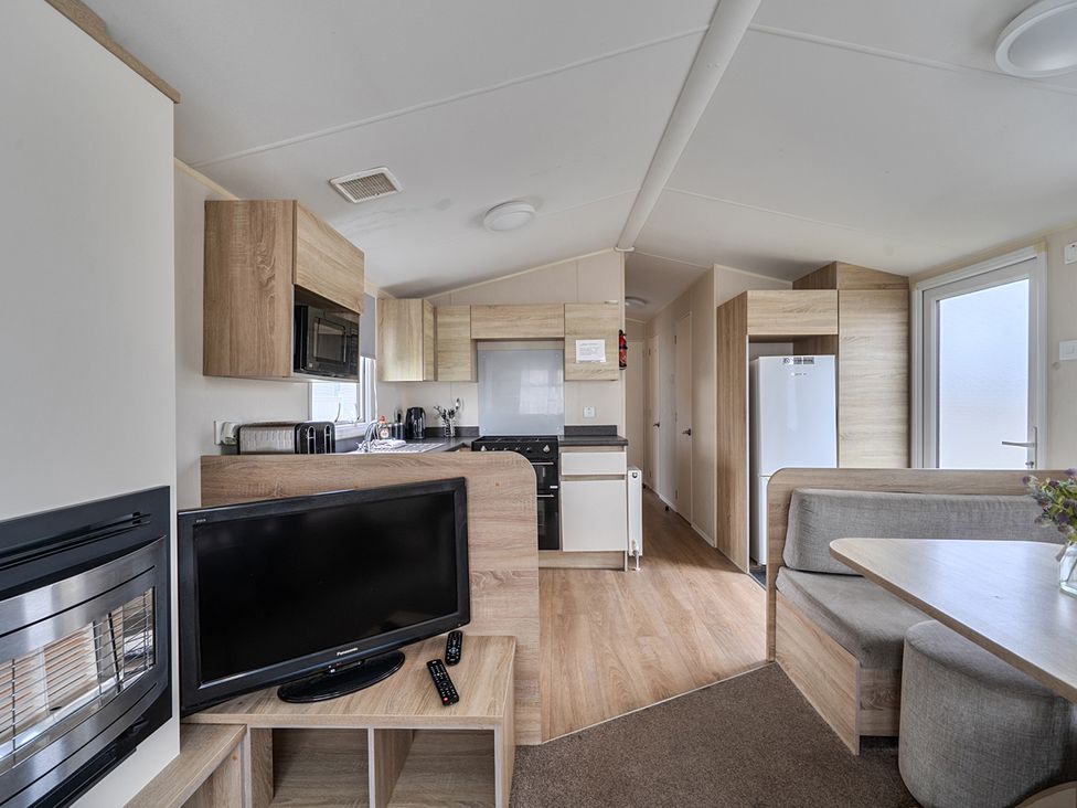 A kitchen and dining area with a television at Pet-friendly lodge near Fistral Beach, Fistral Beach, Newquay