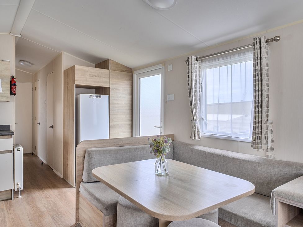 A kitchen with a table and sofa at Pet-friendly lodge near Fistral Beach, Newquay