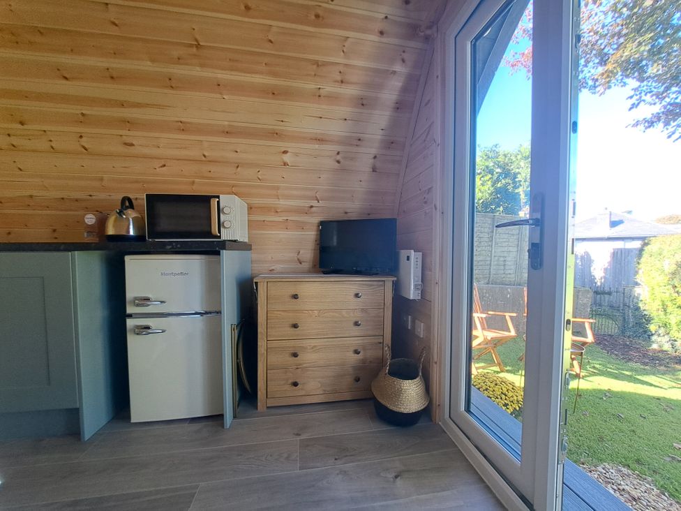 A kitchen with appliances and a view of the garden at tbc in 