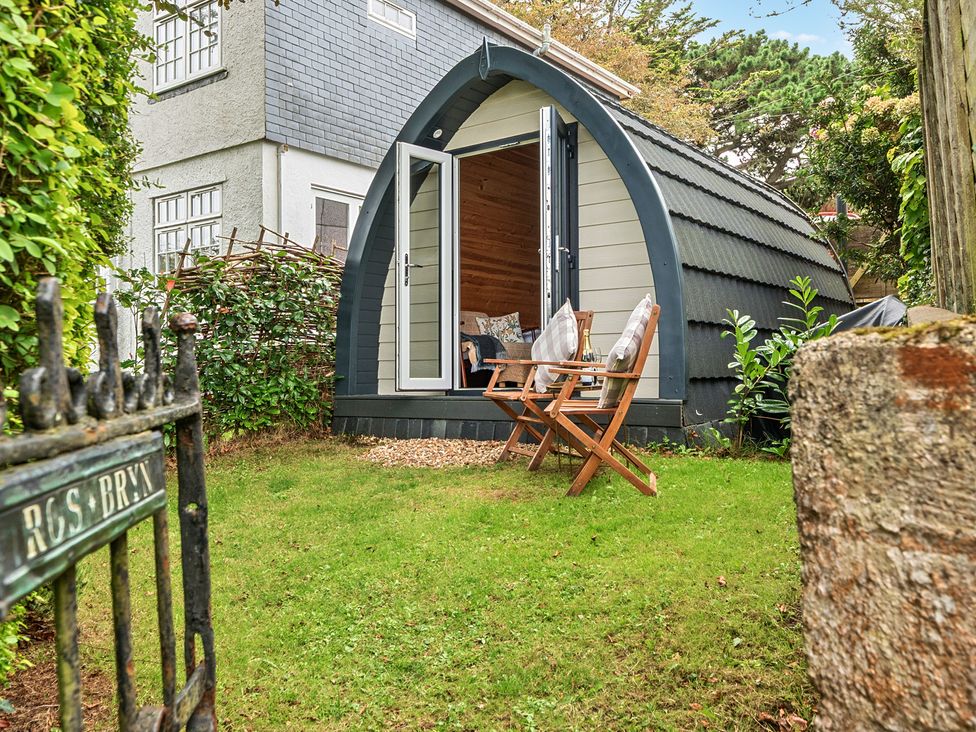 A garden with a pod structure and chairs at Peaceful pod with bay views, walk to 3 beaches St Ives